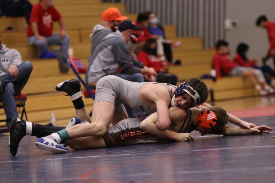 Moving on top, freshman Dillon Cooper works to pin his opponent.