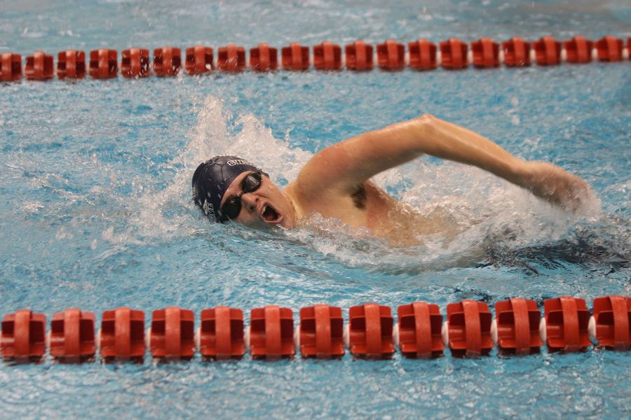 Mid-stroke, senior Noah Collins competes in the 200-yard IM.