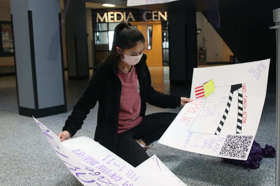 Looking through the posters,  junior Jada Eggleston picks which poster she wants to hang up. 