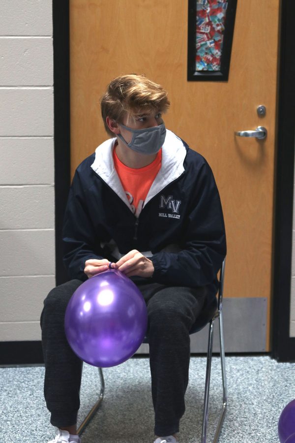 Junior Bret Weber ties up the balloons that will be used to decorate the halls.
