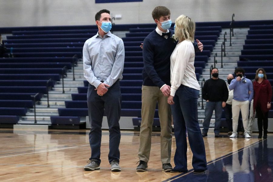 While his name is announced, senior Drew Kline goes in to hug his mother before joining senior Sophie Hannam.