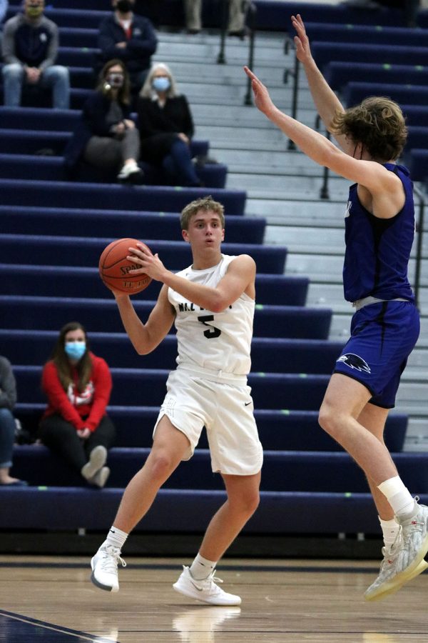 Looking at the other side of the court, junior Jackson Van Dyke protects the ball while looking to make a pass to his teammates.