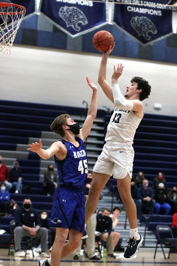 With his opponent in front of him, senior Pete Janssen jumps up in the air to make the shot.