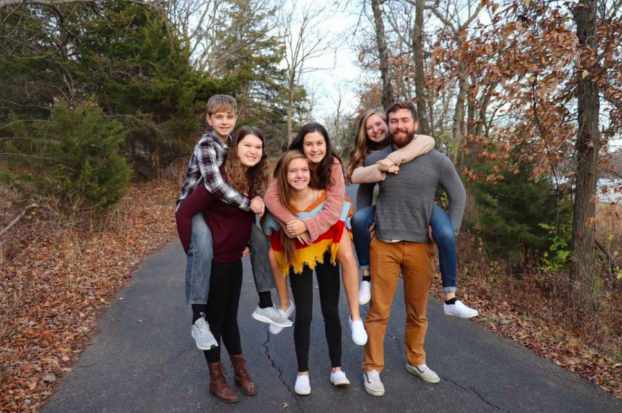 Posing for a family portrait, senior Emily Feuerborn smiles alongside her siblings including her eldest sister Megan, who she says had a profound impact on her identity.” 