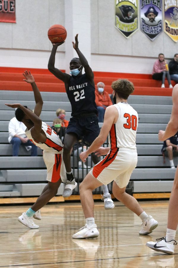 Jumping between two opponents, sophomore Nen Matlock makes the shot for another two points. 