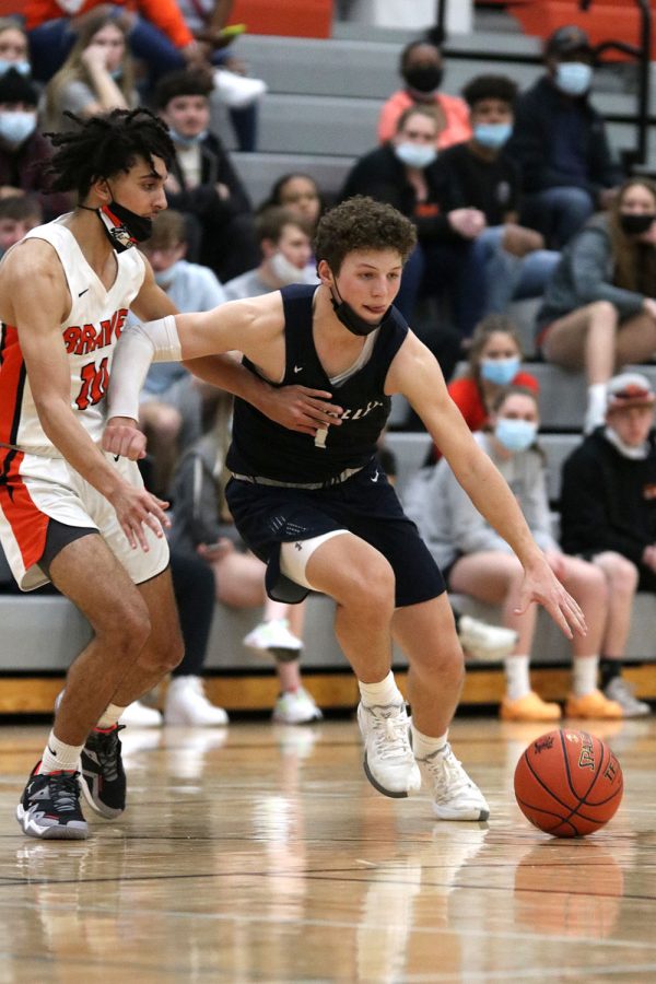 Blocking the ball with his arm, senior Nick Mason dribbles around his opponent.