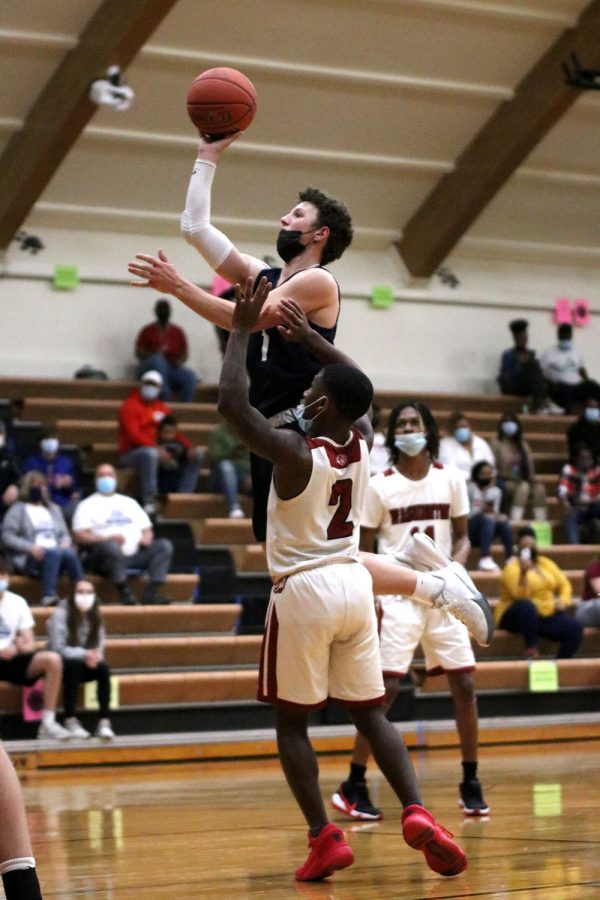 With the ball in his hand, senior Nick Mason attempts to score a basket.