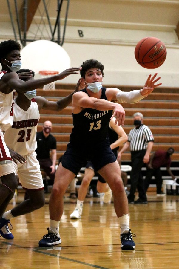 Looking at his teammate, senior Pete Janssen throws the ball to an open player.