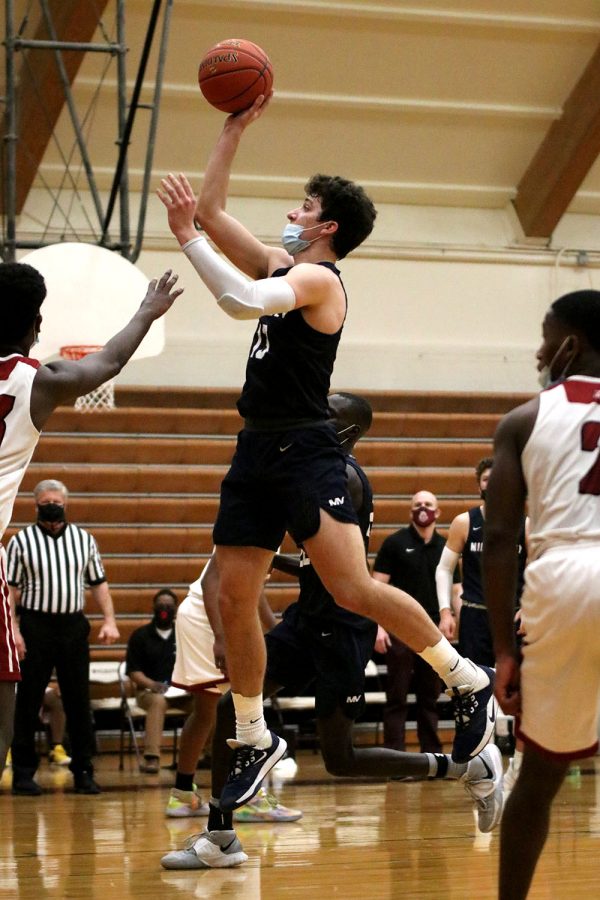 In front of the basket, senior Pete Janssen jumps up to score two points. 