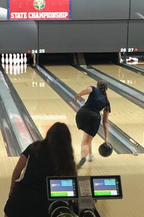 Bowling is Kiara Gozalez hoping to get all ten pins for the teams overall score. Watching her is senior Carlie Bradshaw, making sure she gets a strike.