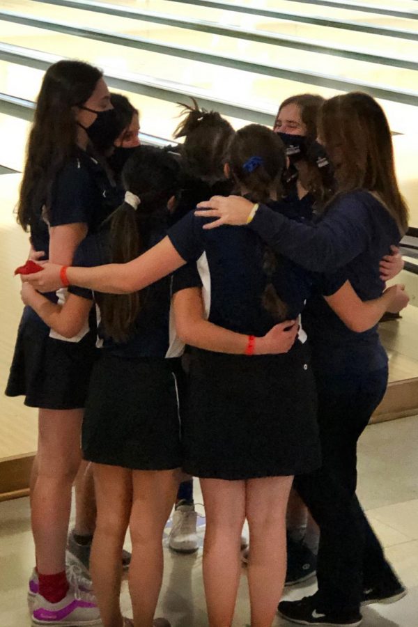 Huddling together with the rest of the girls bowling team, head coach Amy McClure congratulates them for the good work they have done at state. 