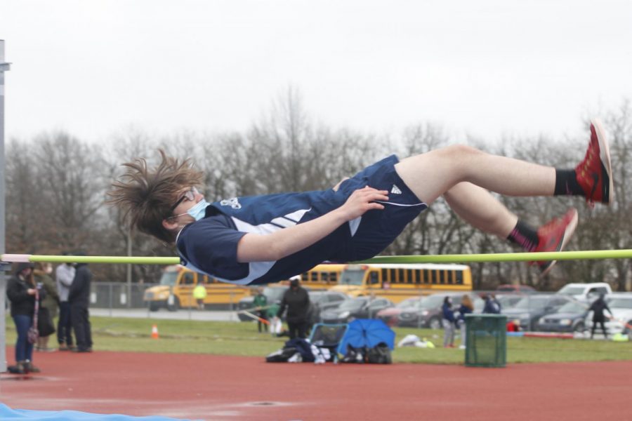 Contorting his body over the bar, freshman Nicholas Billinger prepares to land on the high jump mat.