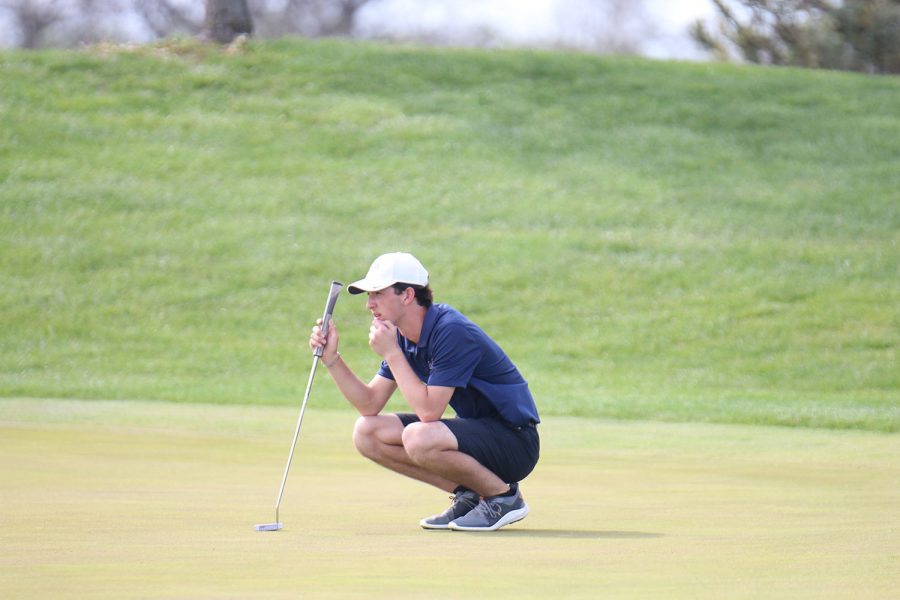 Squatting down, junior Jack Weber plans out where the ball is going to go. 