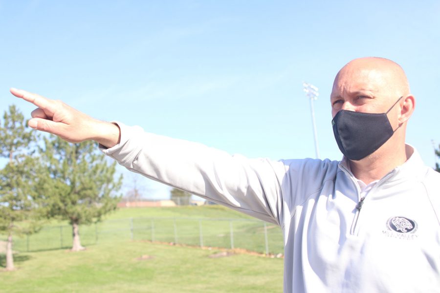 Pointing out, science teacher Eric Thomas directes the class to where a bird is heard. 
