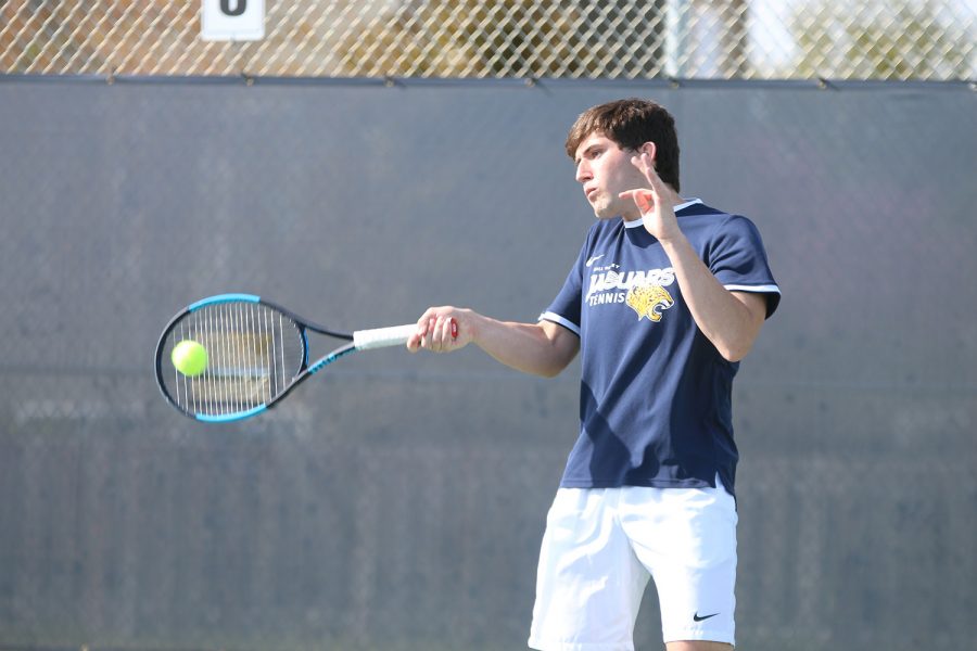 Focused, senior Keaton Verdict hits a forehand. 
