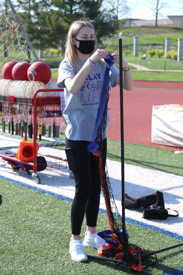 Helping to prepare for the badminton tournament, junior Carly Hey sets up nets for later in the night. 
