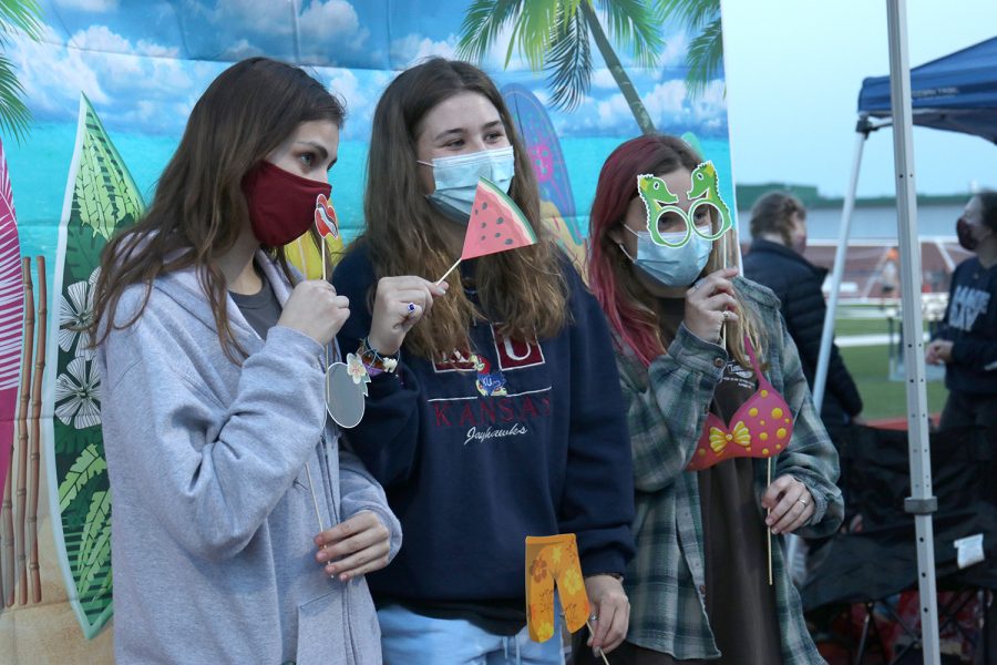 Posing for a picture, junior Quinn Franken enjoys the Hawaiian photo booth with her friends. 
