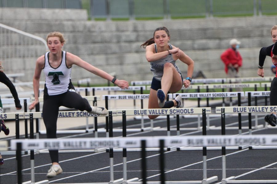 Over a hurdle, junior Quincy Hubert runs in the 100 meter hurdles. Hubert was also an event champ in the 300 meter hurdles.