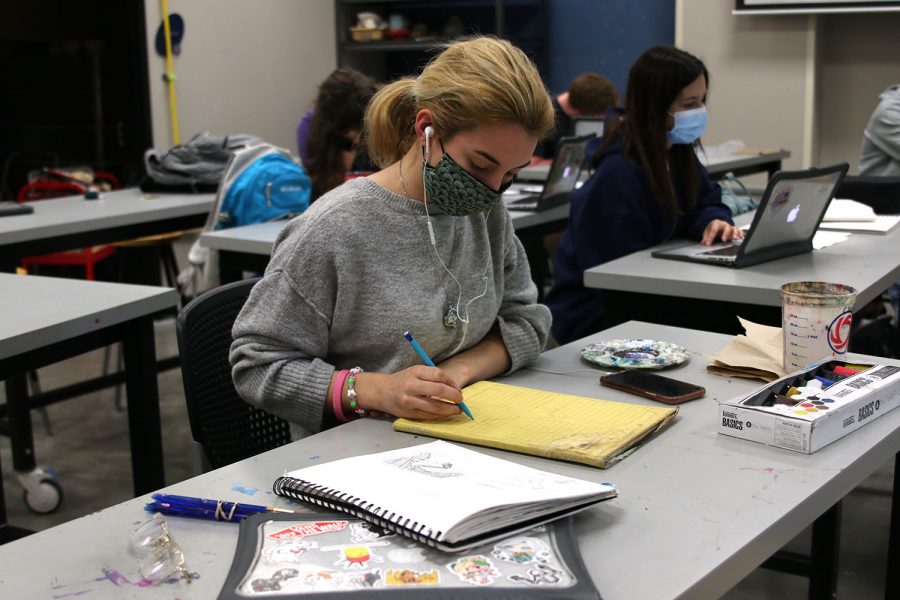 Intently gazing down at her sketchbook, junior Natalie Hernandez begins to sketch her plans for her painting on Thursday, April 8.  