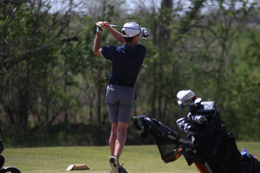 Swinging his club, sophomore Codey Geis drives his ball down the course.