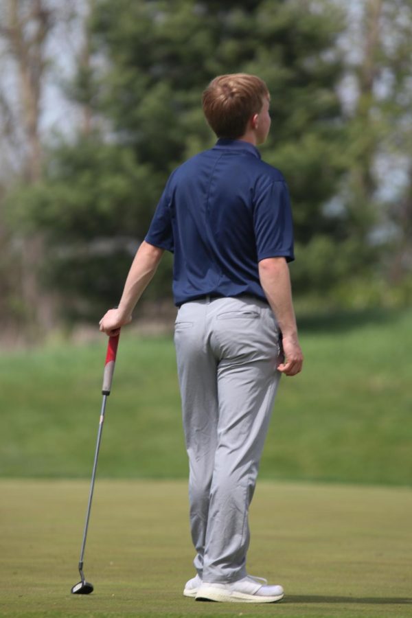 Observing his opponents putt, sophomore Matt Morgan waits patiently for his turn.