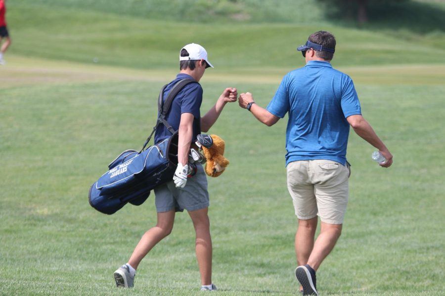 Fist bumping his coach, junior Brock Olson celebrates his hit.