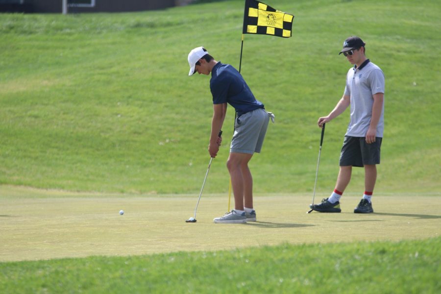 Lining up his shot, junior Brock Olson takes his turn putting.