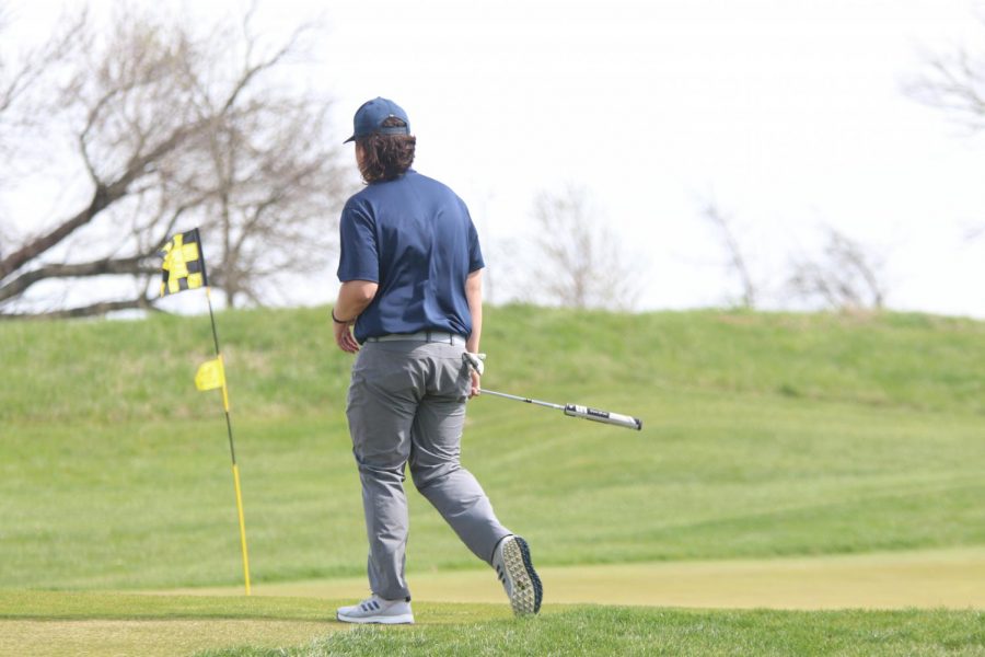 Approaching the green, sophomore Karson Chalupnik takes his turn putting.