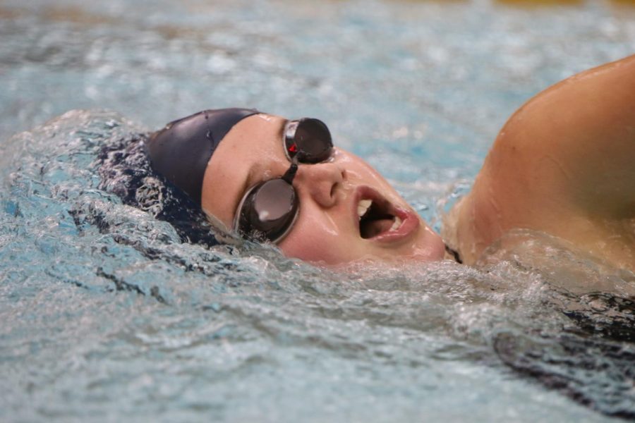 Taking a breath of air, Senior Emma Cross swims the freestyle at the Blue Valley High School Girls Triangular on Tuesday, April 13.