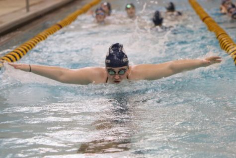 Sophomore Hannah McLeod warms up for the meet while her teammates watch.