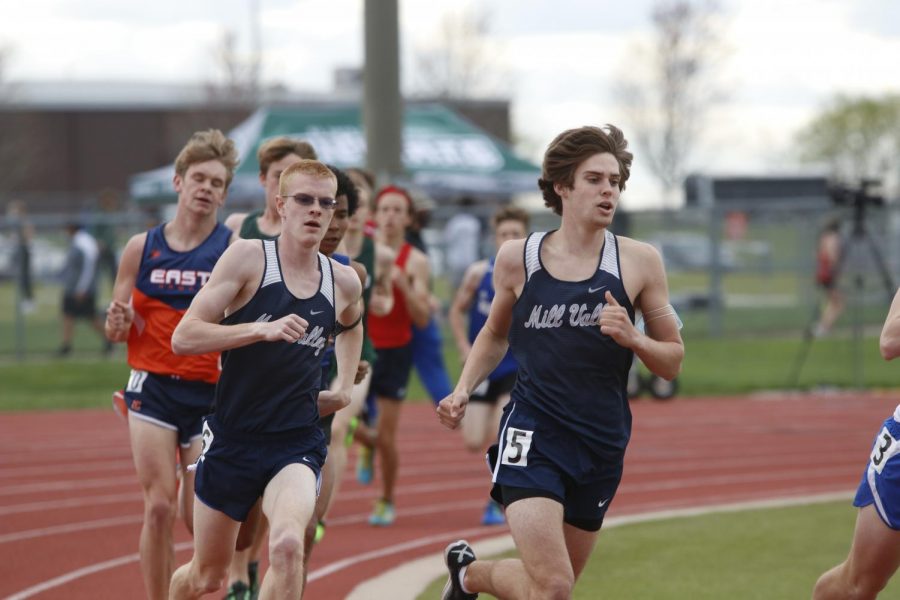 Rounding the corner of the track, senior John Lehan and junior Chase Schieber fight to maintain their places in the 1600m race. Lehan placed 8th and Schieber placed 9th.