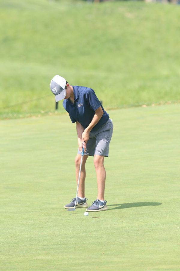 With steady hands, sophomore Codey Geis putts the golf ball 
