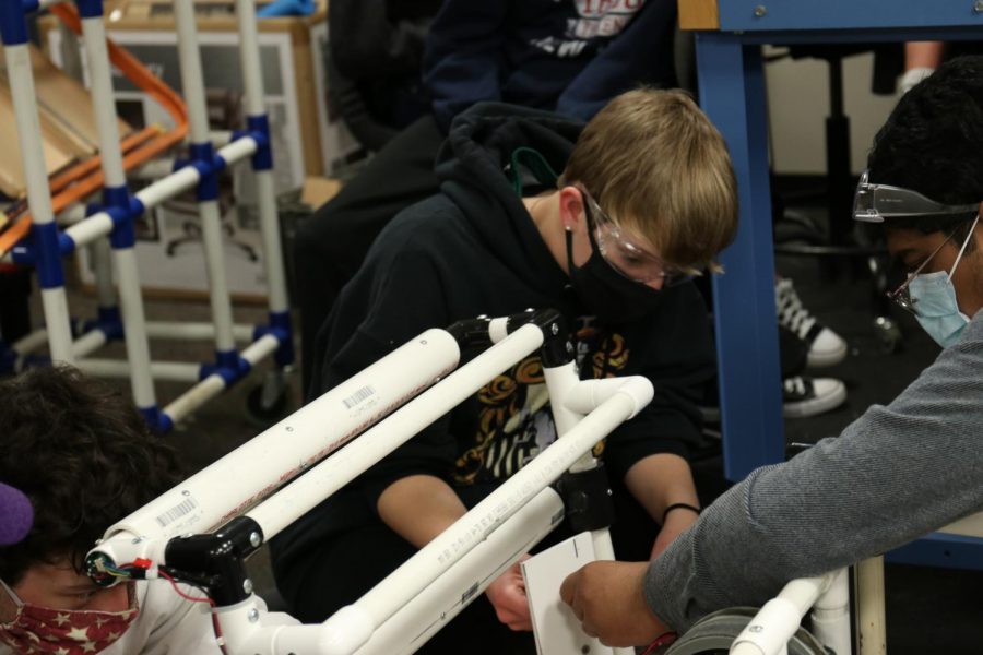 De Soto sophomore Julie Steeb adjusts a guide on the teams robot Thursday, Feb. 11