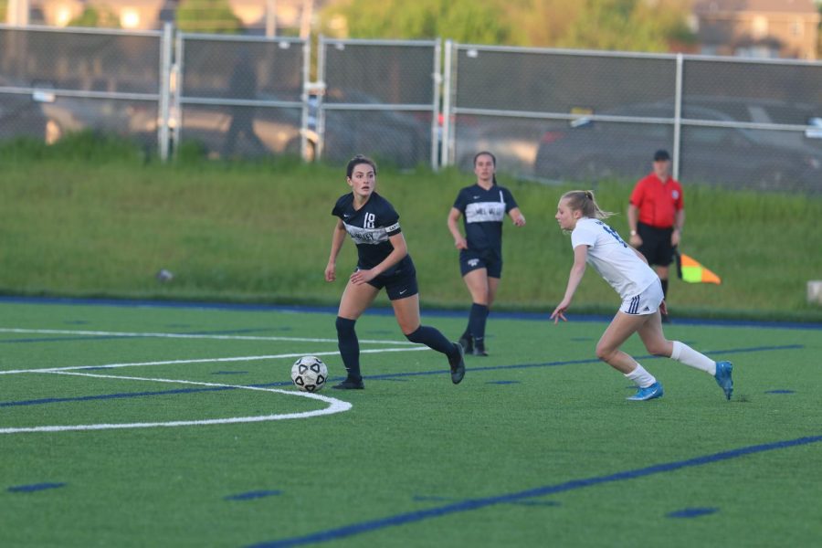 Looking for someone to pass to sophomore Gracie Knight gets the ball past mid field. 