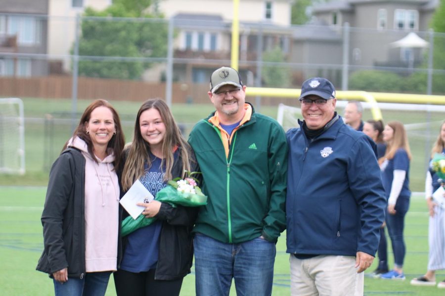Posing with her parents and girls soccer head coach Joe Waldron senior Ryleigh Reigle holds her bouquet of flowers. 