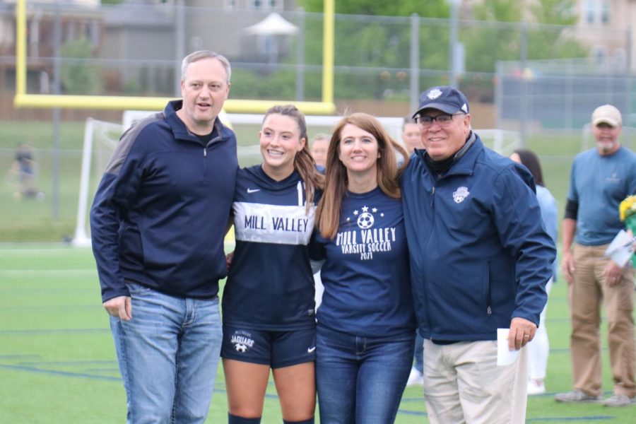Posing with her parents and head girls soccer coach Joe Waldron senior Kathrine Weigel smiles to the crowd. 