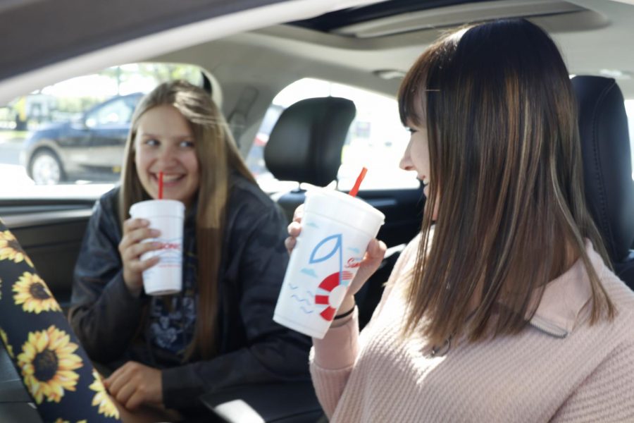 Laughing while conversing about band Thursday, May 6, senior Ella Greenup and freshman Kate Marten get Sonic with one another - an activity they do often together.