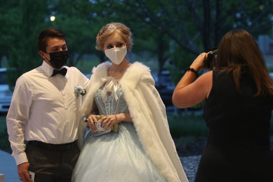 Prom sponsor Angie DalBello takes a photo of a couple arriving at the dance.