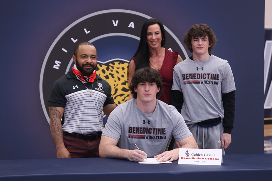 Senior Caiden Casella signs and poses with his parents. Casella will attend Benedictine college for wrestling.
