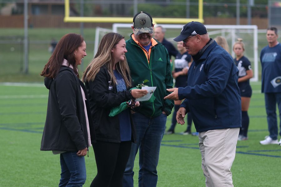 Girls soccer head coach Joe Waldron congratulates senior girls soccer manager Ryleigh Reigle. 