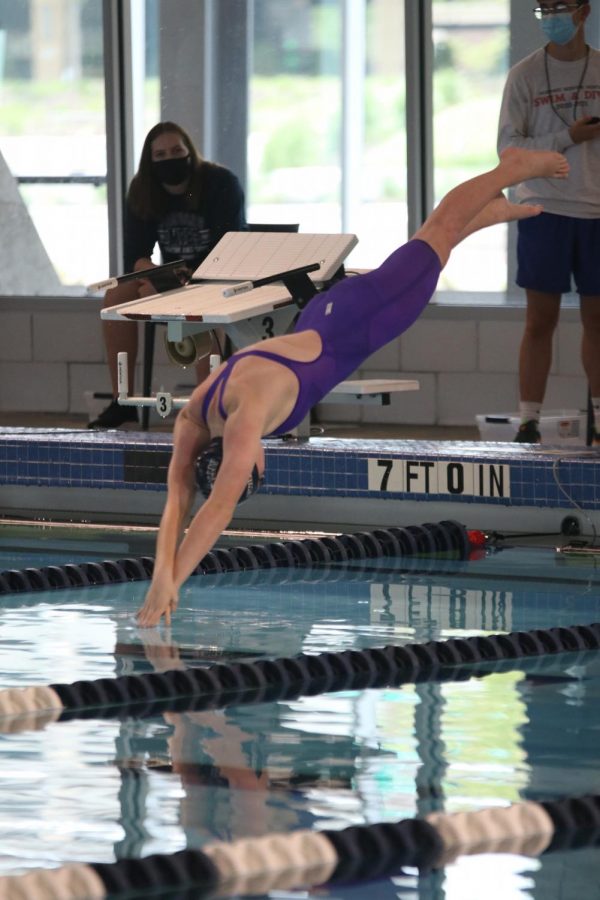 Entering the water, freshman Ella Hansen dives into the pool.