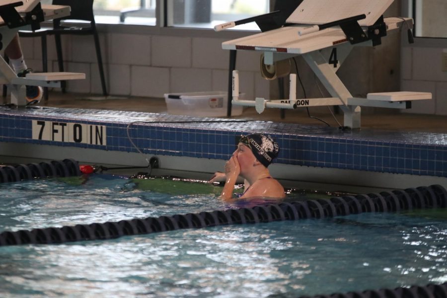 Covering her mouth, freshman Ella Hansen reacts to her 200 yard freestyle time.