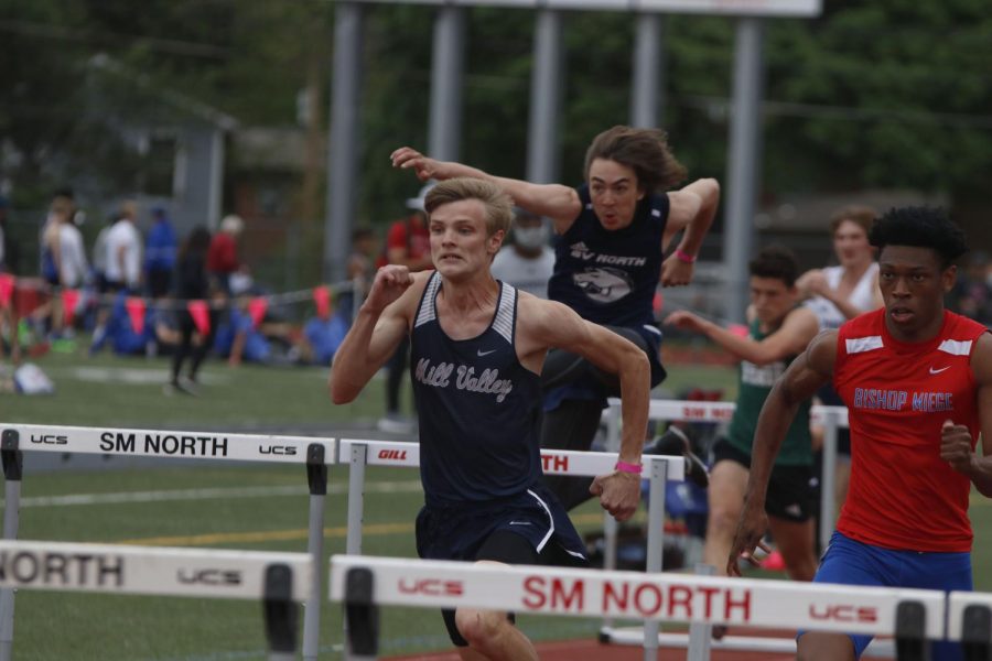 Neck and neck with Bishop Miege, senior Leif Campbell sprints to the next set of hurdles in the 110m hurdle race. Campbell placed 6th in finals with a time of 15.68 seconds.