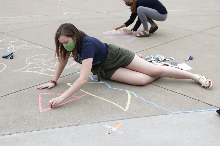 Creating a sailboat, NHS officer Taylor Moss uses various colored chalk to make her artwork vibrant.