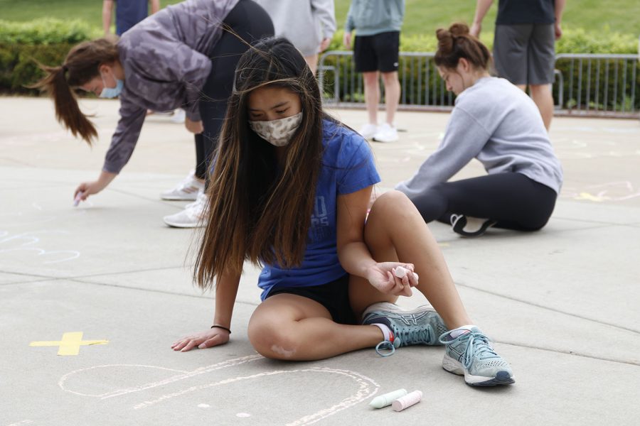 Glancing at her artwork, NHS member junior Jada Eggleston plans out what shes going to write next to elementary students at Prairie Ridge Elementary School on Monday, May 3.