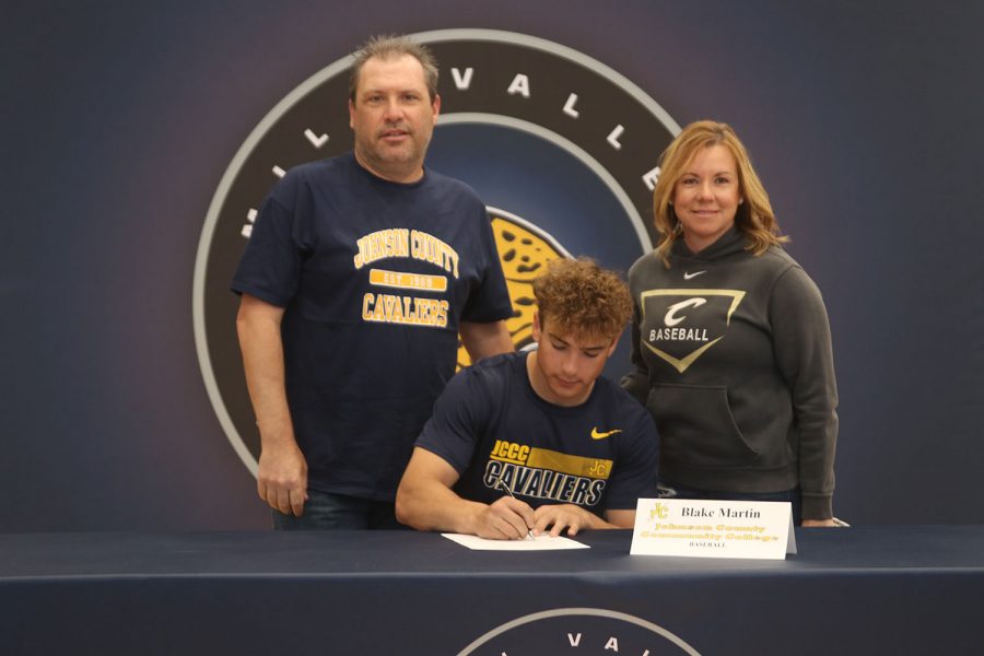 Senior Blake Martin signs and poses with his parents. Martin will attend Johnson County Community College for baseball.