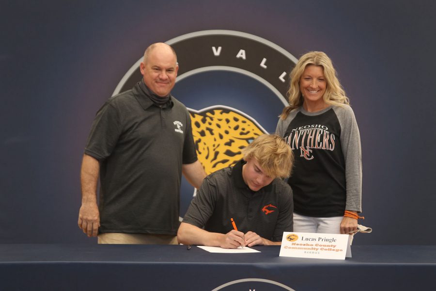 Senior Lucas Pringle signs and poses with his parents. Pringle will attend Neosho County Community College for baseball.