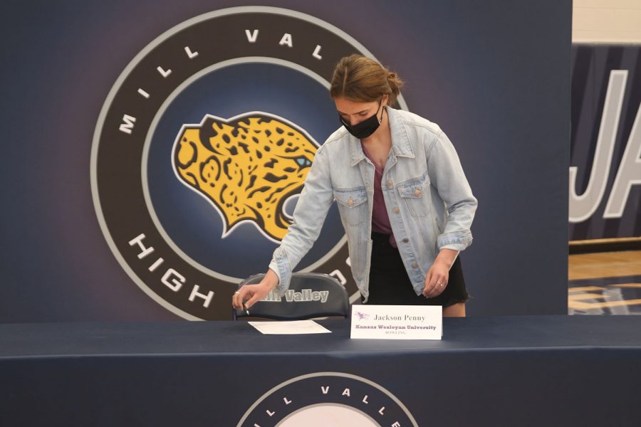 Setting up the table in-between each signing, junior Logan Pfeister places a pen on the table.