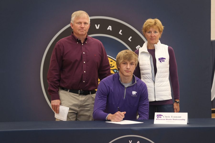 Senior Chris Tennant signs and poses with his parents. Tennant will attend Kansas State University to play football.