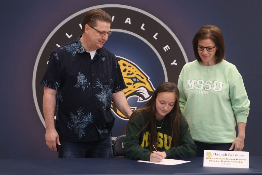 Senior Hannah Beashore signs and poses with her parents. Beashore will attend Missouri Southern State University for soccer.